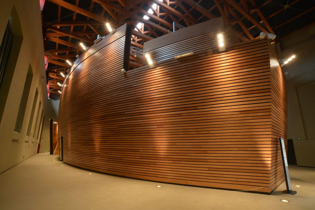 Parete curva in legno nell’aula magna.